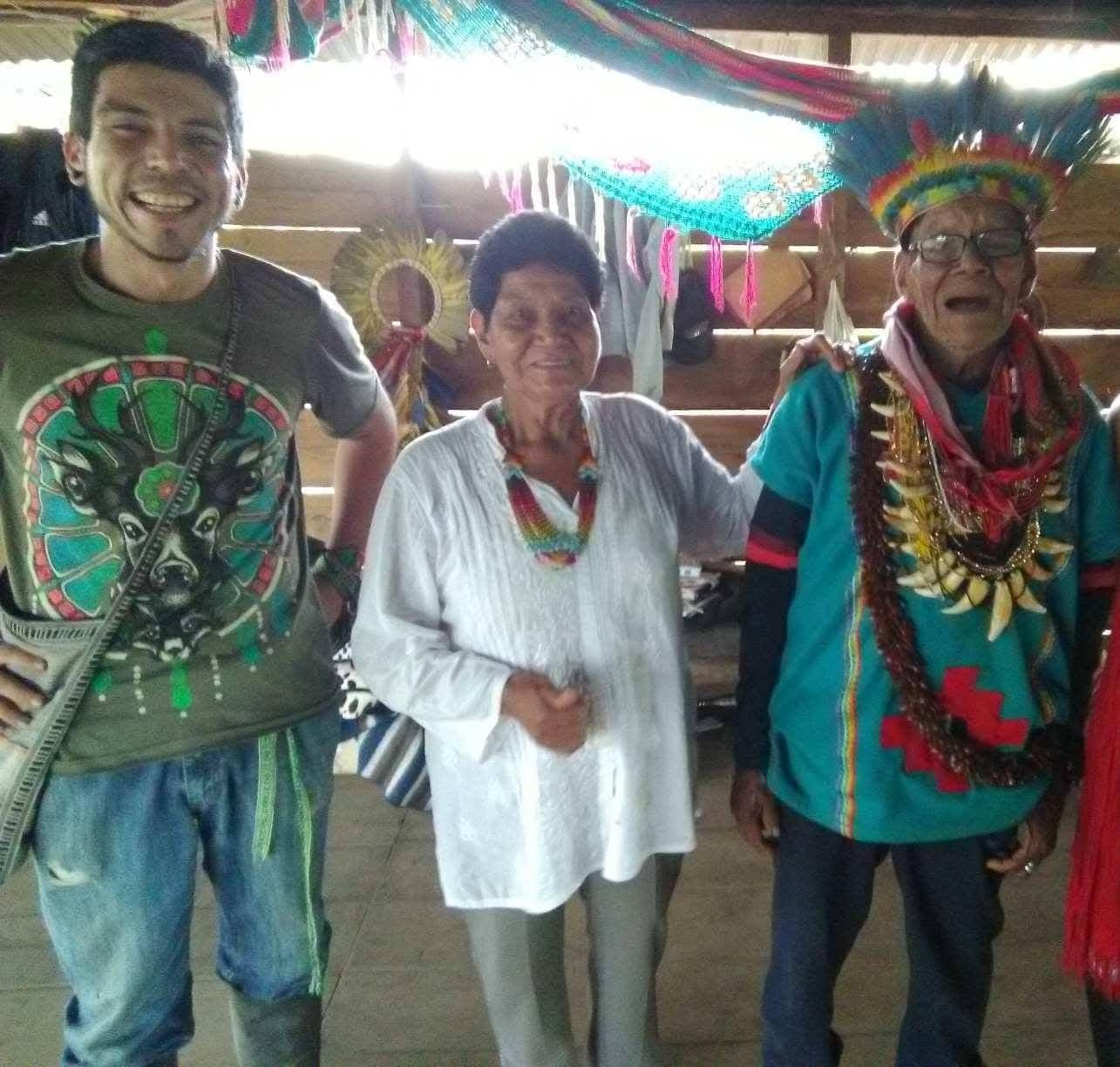 Gabriel with elder Indigenous medicine carriers inside a traditional maloka