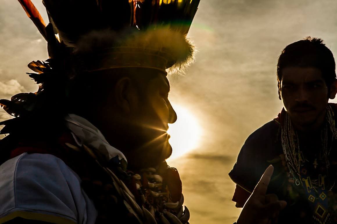 Gabriel Guillén in silhouette beside a Taita at sunrise