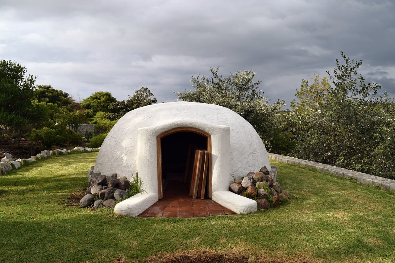 The temazcal — white-domed sweat lodge under cloudy Andean sky