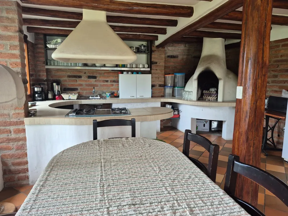 Bunk bed beneath a round brick portal window in a participant cabin at Teos