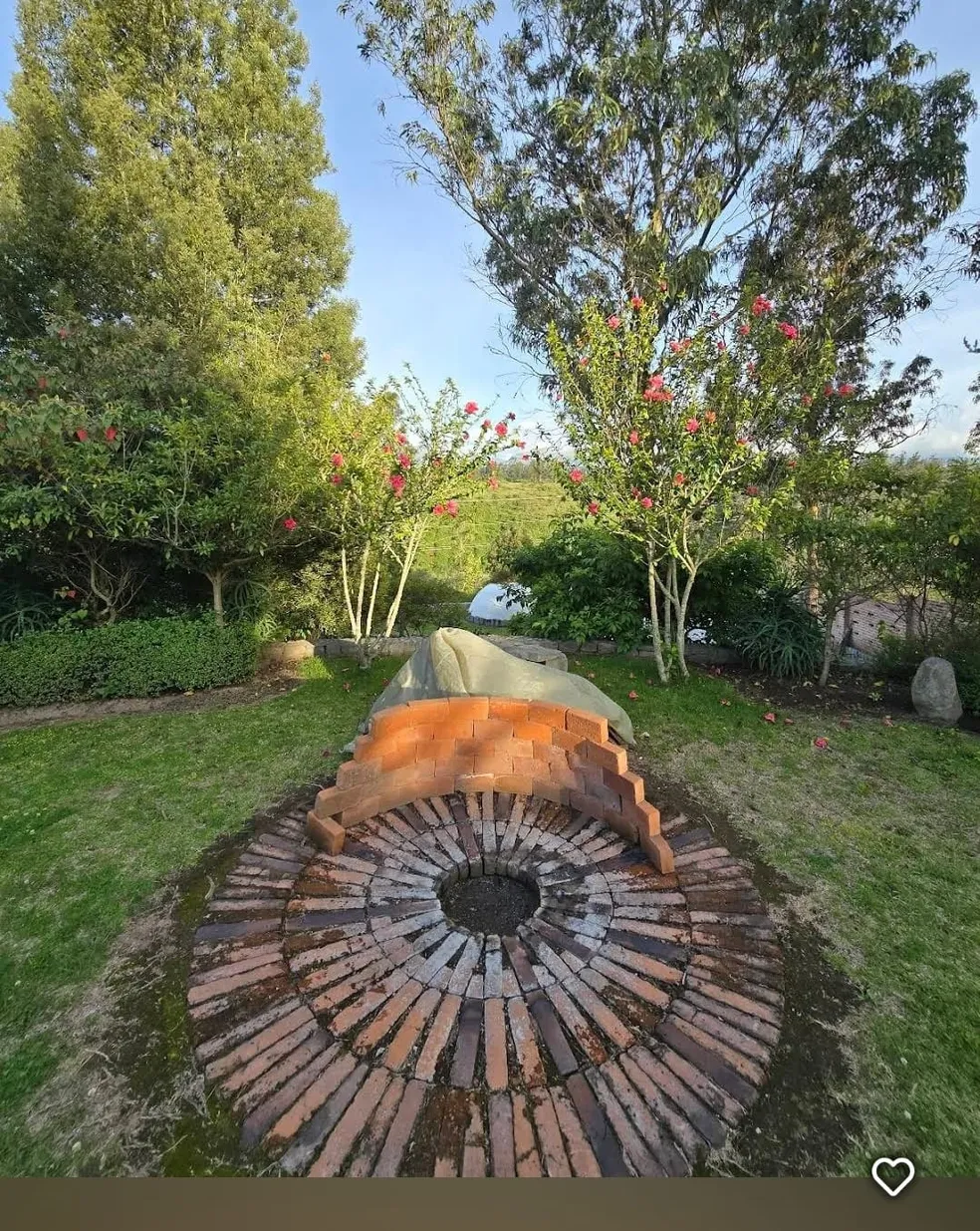 Brick fire-circle in the garden at Teos, surrounded by flowering trees